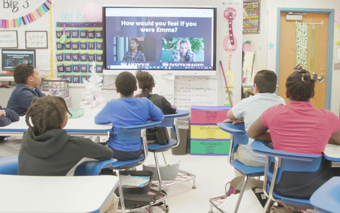 Students in classroom with hands raised